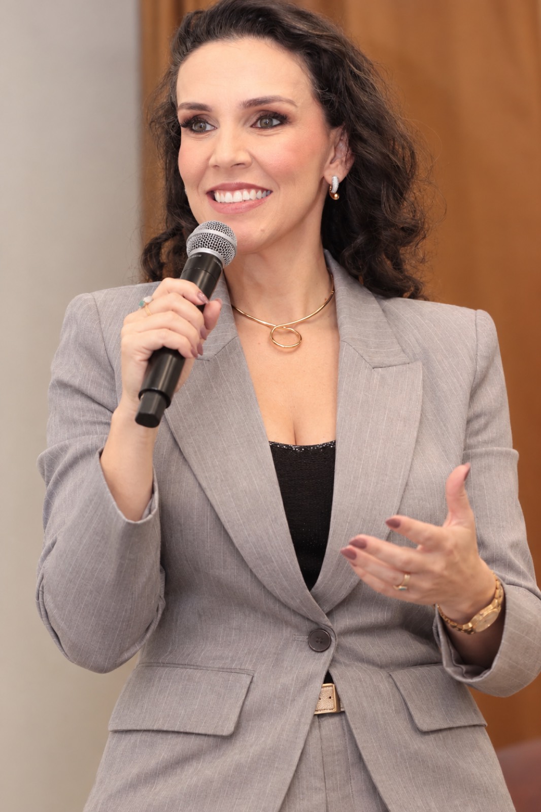 Tati falando ao microfone durante uma palestra